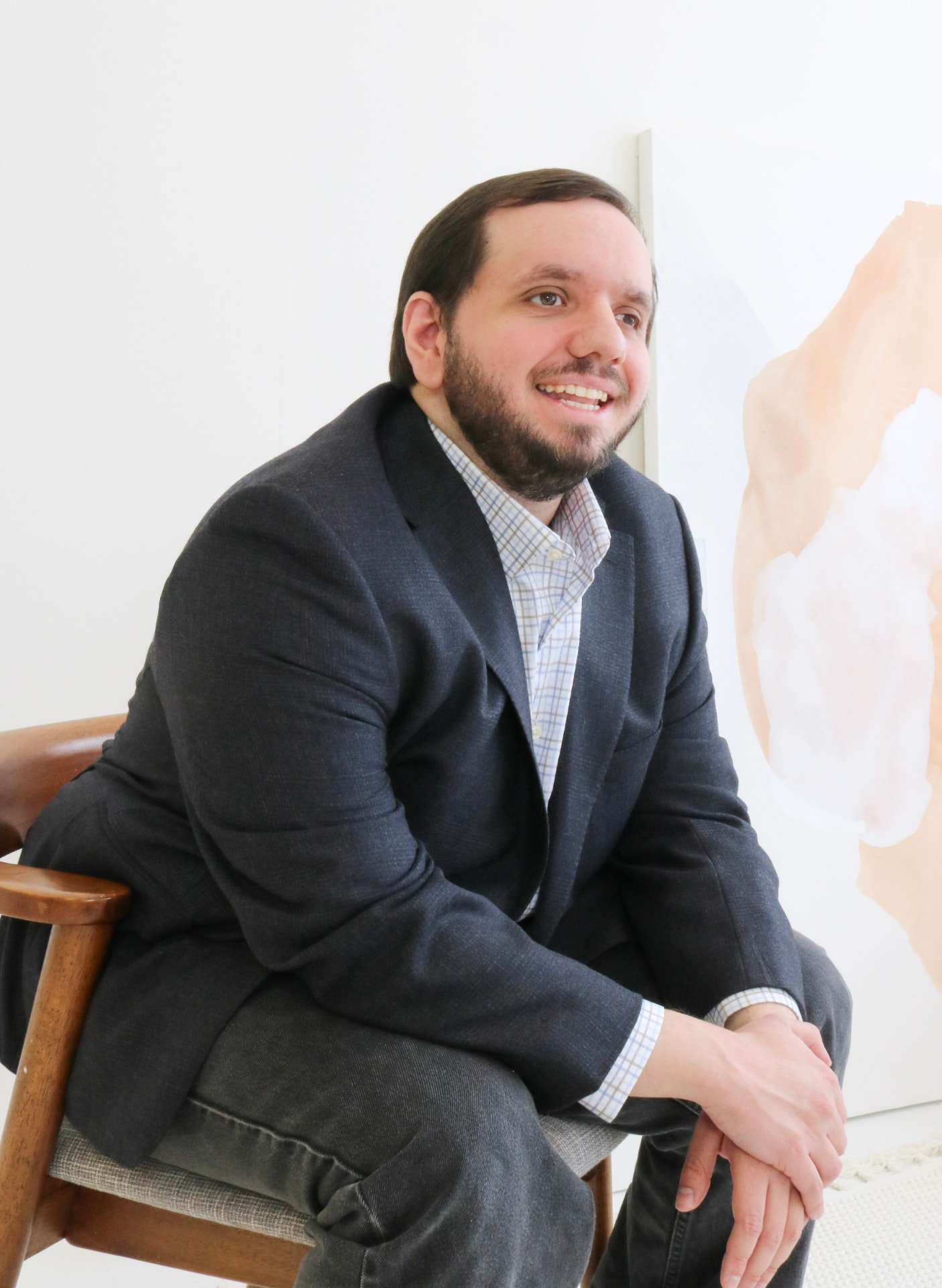 Brandon Schiafone, registered social worker, seated and leaning forward with a warm smile